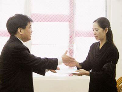 Ông Trần Văn Quang trao tiền bảo hiểm quân nhân cho chị Nguyễn Thị Hải - vợ Thượng tá Nguyễn Văn Vinh