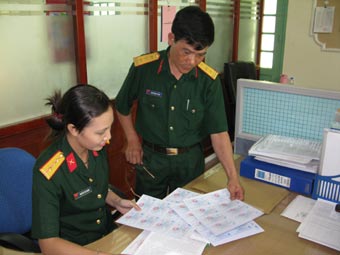 Cán bộ cơ quan Bảo hiểm xã hội Bộ Quốc phòng kiểm tra các thông tin trên thẻ BHYT trước khi cấp cho thân nhân quân nhân.