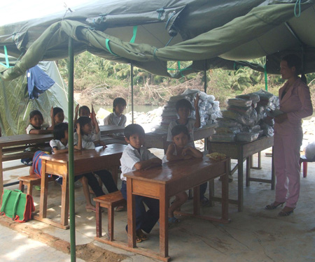 Học sinh trường tiểu học Xuân Lâm hiện đang học trong nhà bạt do bộ đội địa phương dụng tạm và bàn ghế, sách vở do Báo SGGP mua tặng (Tr L.V)